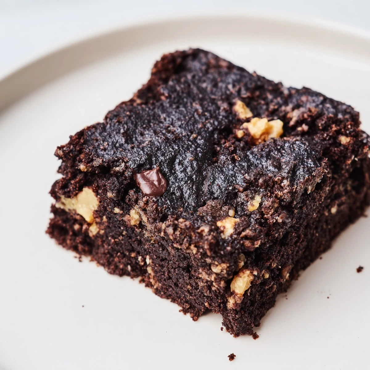 Freshly baked Gluten Free Almond Flour Brownies with melty dark chocolate chips on a rustic wooden cutting board, ready to serve.