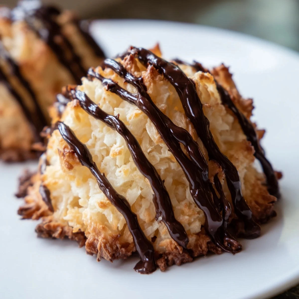 Chewy toasted coconut macaroons with rich chocolate drizzle, perfect for holiday dessert platters.