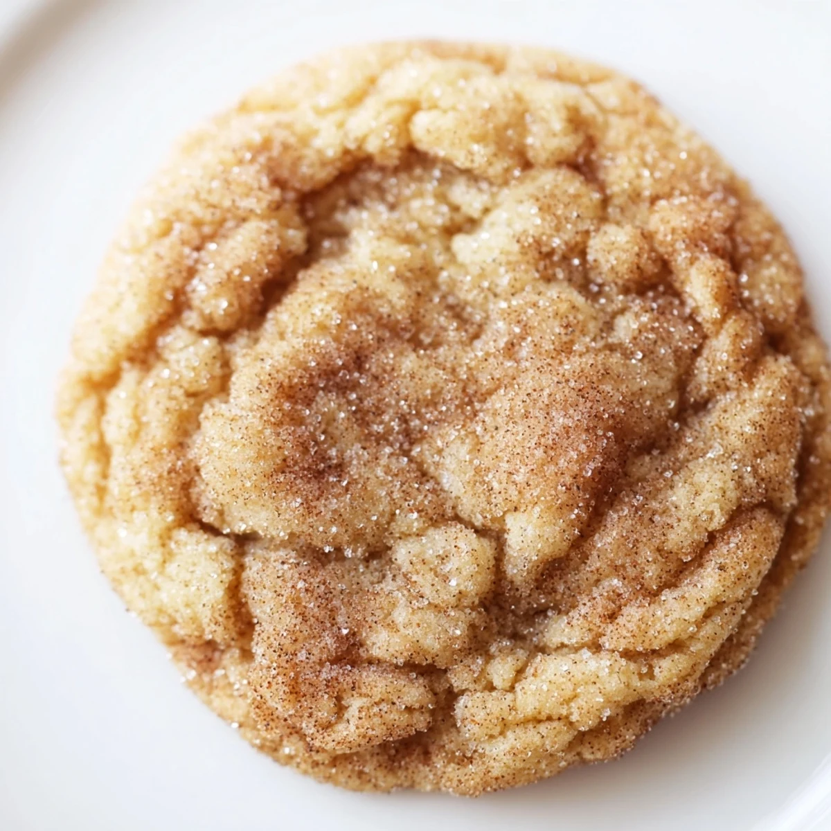 Golden-brown Chewy Cinnamon Sugar Cookies cooling on a wire rack, showing cracked edges.