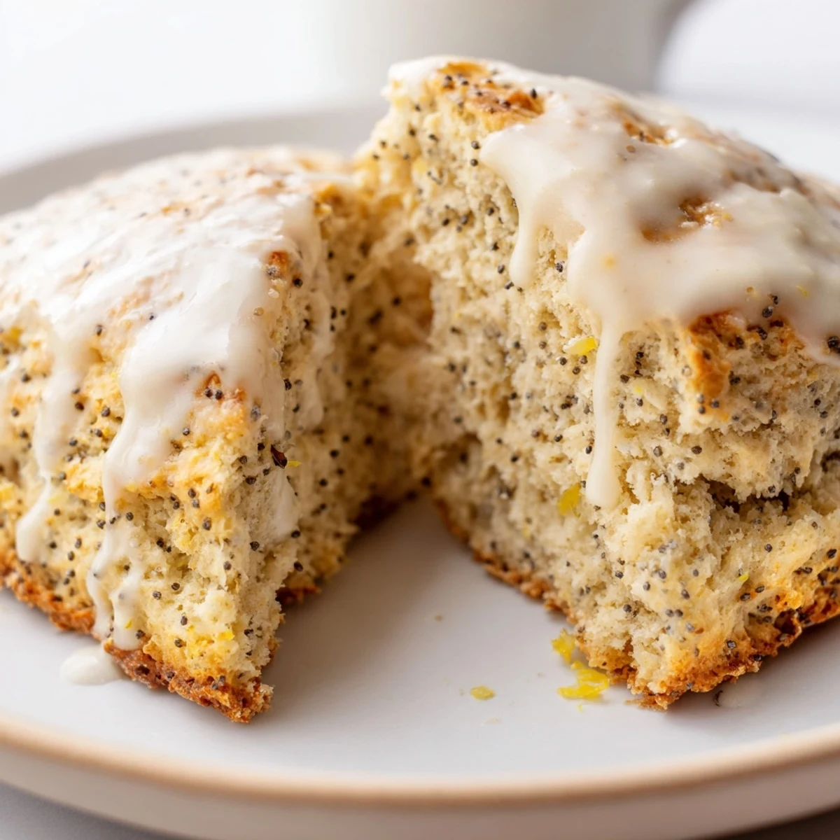 Freshly baked Lemon Poppy Seed Scones with a thick, white glaze drizzled over golden edges, ready to serve.