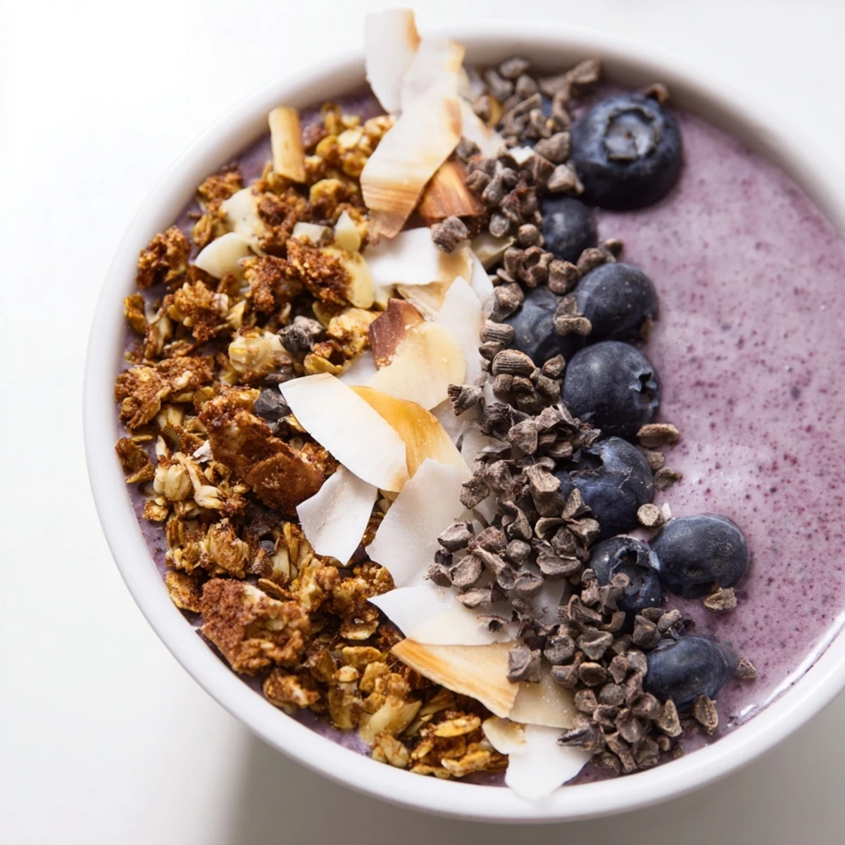 Close-up of a Winter Berry Smoothie Bowl, featuring chia seeds and pumpkin seeds on a creamy, colorful base.