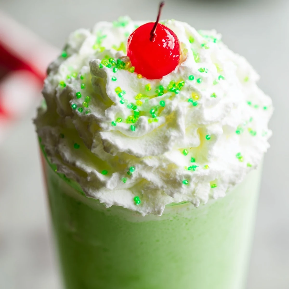 Creamy Shamrock Shake with Whipped Cream topped with fluffy swirls in a frosted glass, perfect for St. Patrick's Day.
