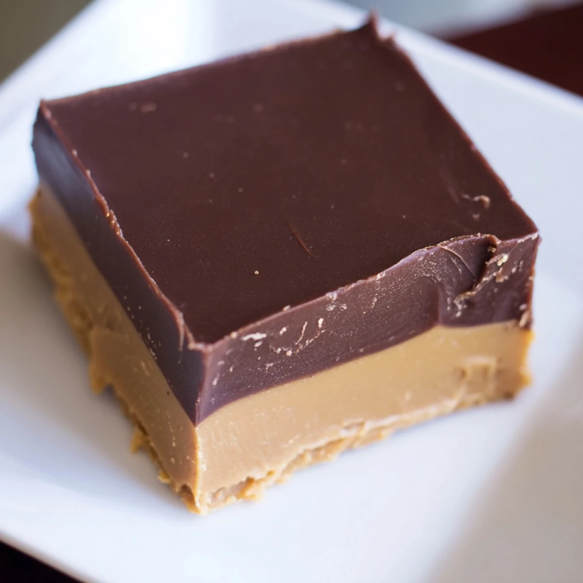 Homemade Chocolate Peanut Butter Fudge squares stacked neatly, with a soft, melt-in-your-mouth texture perfect for gifting or a party platter.