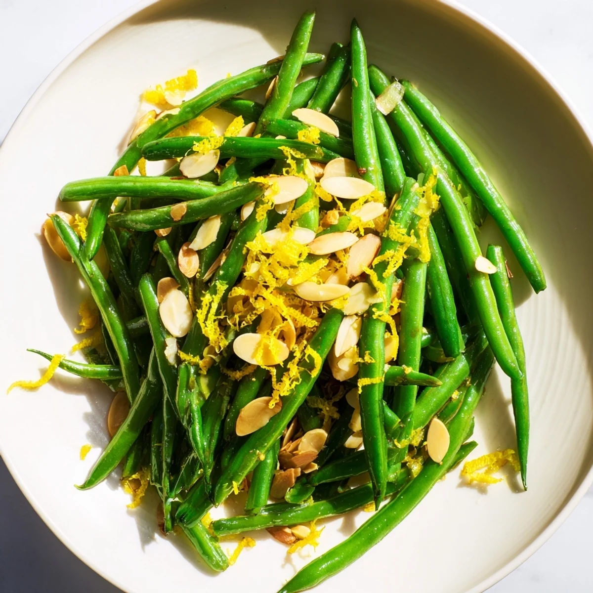 Crisp-tender green beans with toasted almonds and lemon zest, served as a bright side dish.
