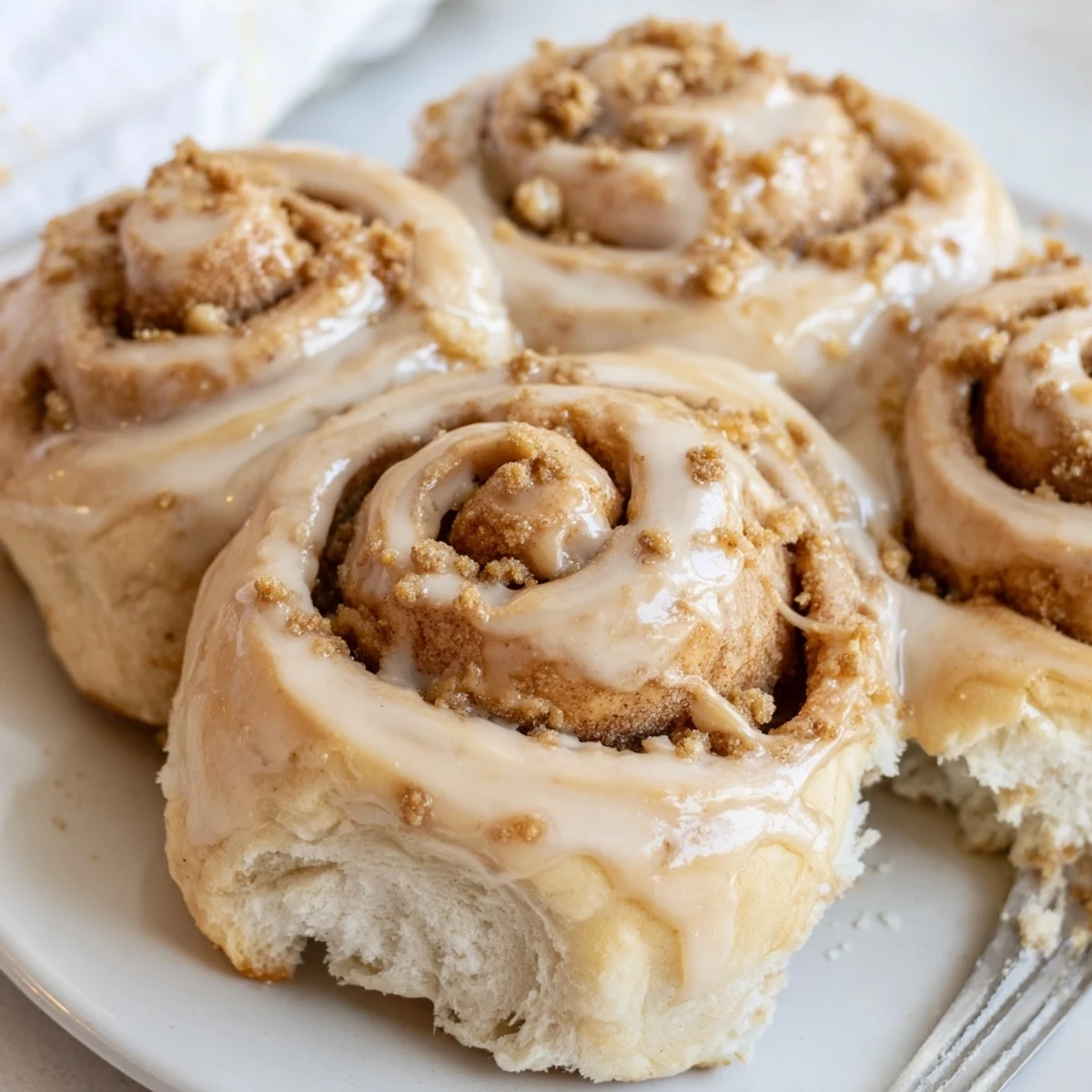 Overhead view of Soft and Gooey Biscoff Cinnamon Rolls in a baking dish, with gooey cookie spread filling and glaze dripping down the sides.