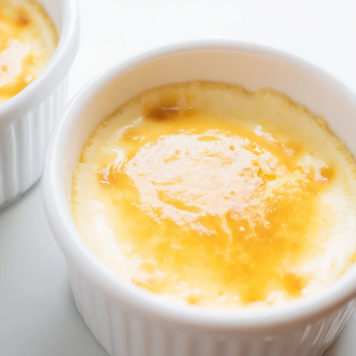 Classic Baked Milk Pudding with a smooth, wobbly texture, shown with a spoon and cinnamon dusting for serving.