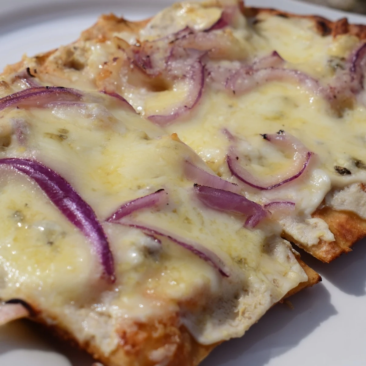 Freshly baked Sweet Heat Honey Garlic Flatbread Pizza with melty mozzarella, red onions, and jalapeños on a wooden board.