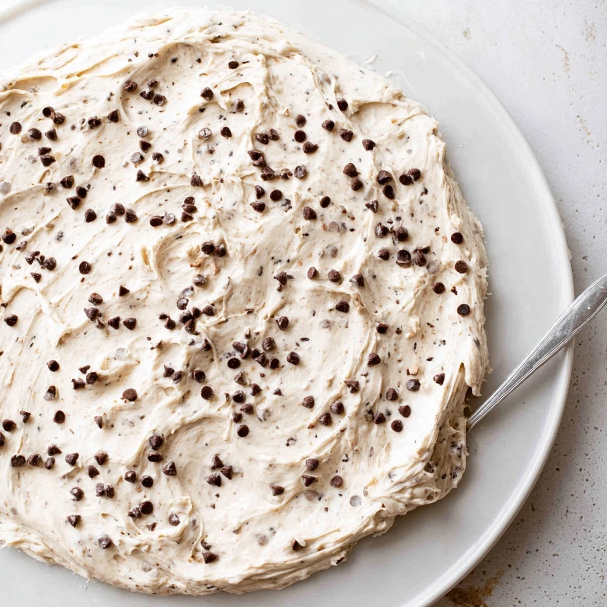 Creamy, edible Cookie Dough Frosting swirled with mini chocolate chips, ready to spread on cooled cupcakes or savor by the spoonful.