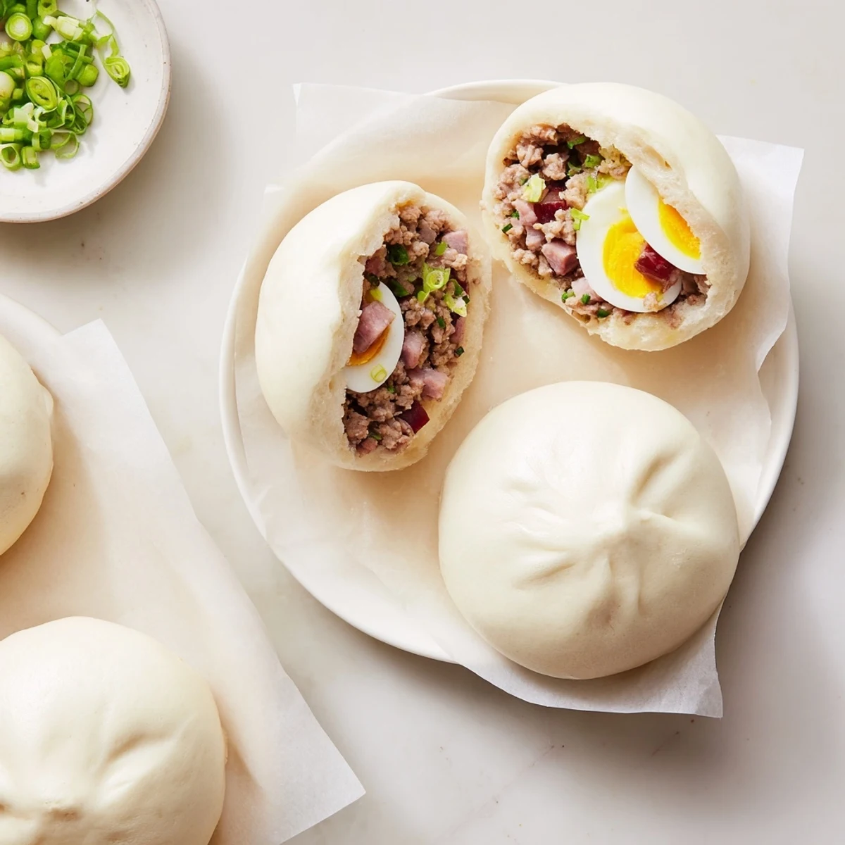 A close-up of a fluffy Banh Bao steamed bun cut open to reveal savory pork, mushrooms, and egg filling.