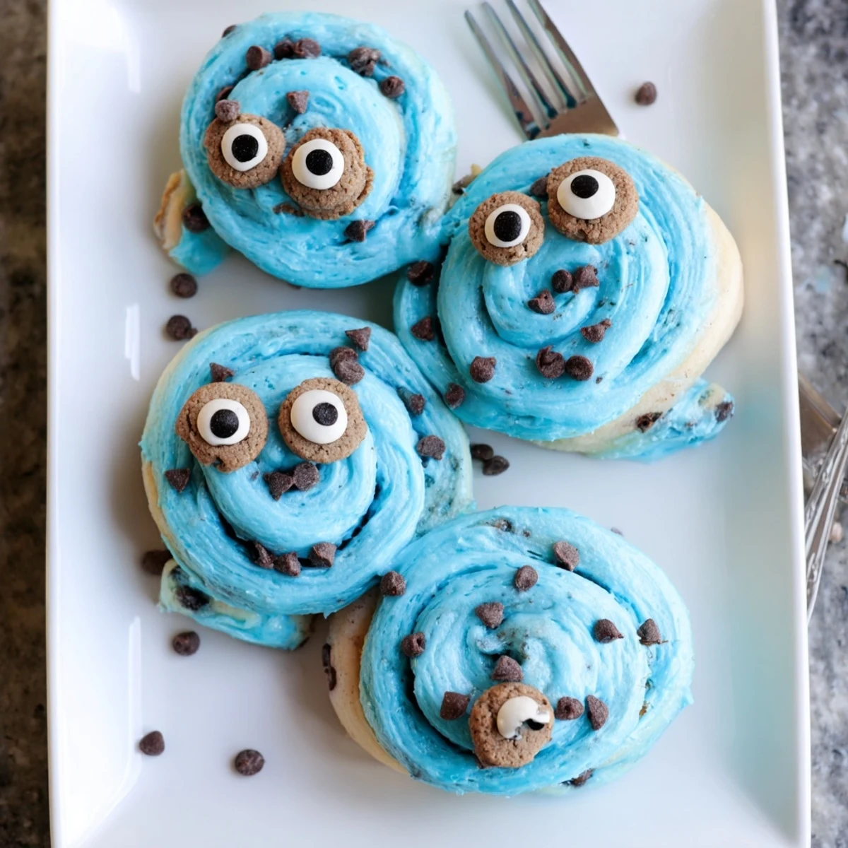 A close-up of vibrant blue Cookie Monster Cinnamon Rolls filled with gooey cinnamon-sugar and chocolate chips.