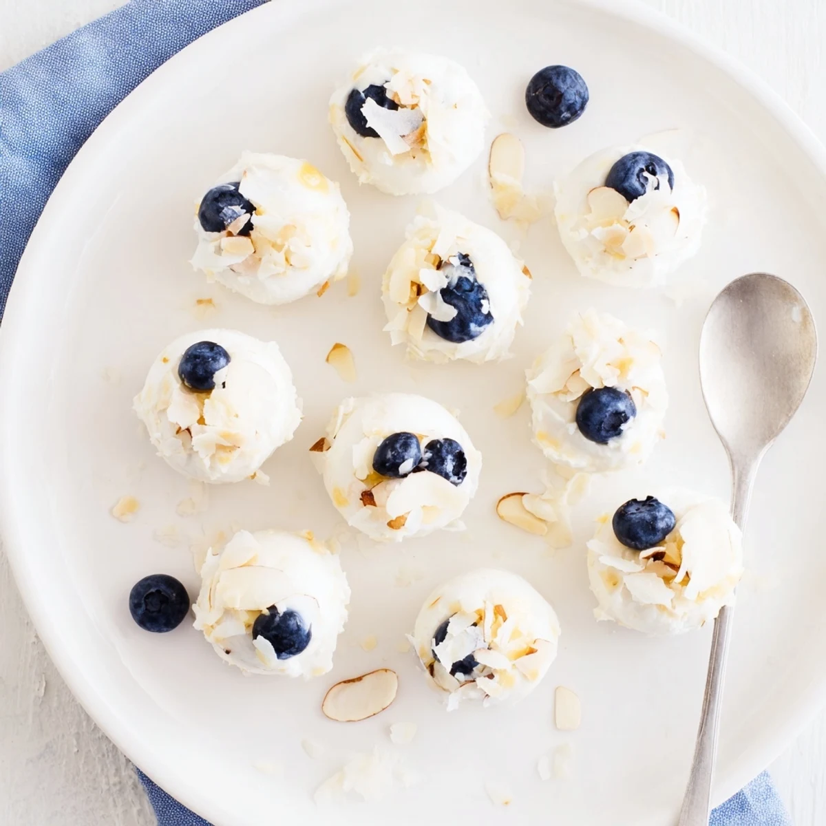 Close-up of creamy Blueberry Greek Yogurt Bites garnished with chopped almonds for crunch.