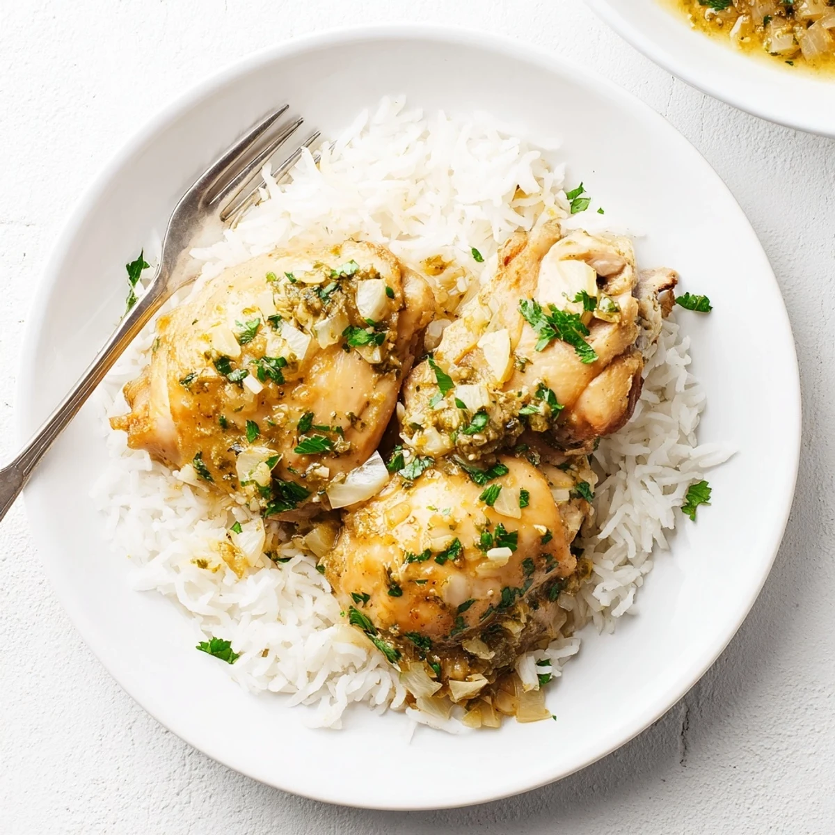 Juicy Slow Cooker Lemon Herb Chicken With Fluffy Rice served steaming in a white bowl with parsley garnish.