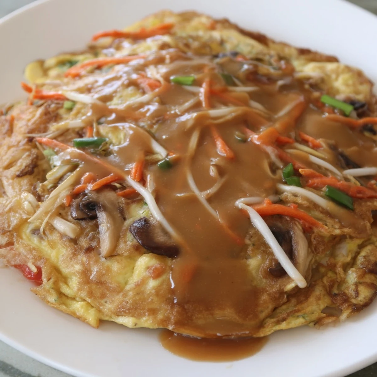 Homemade Egg Foo Young fried to golden perfection and served over steamed white rice