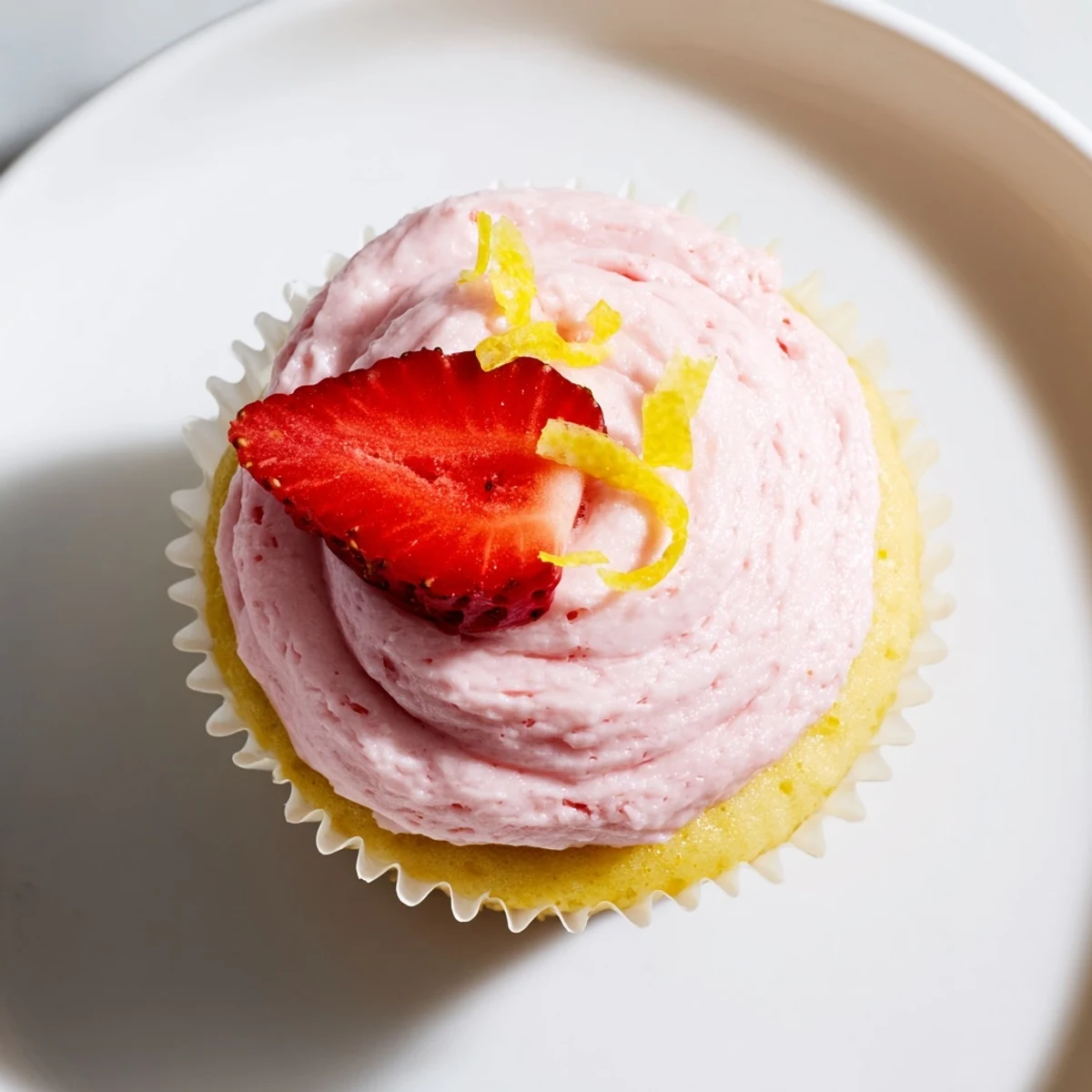Spring lemon cupcakes with swirled strawberry buttercream and fresh strawberry garnish