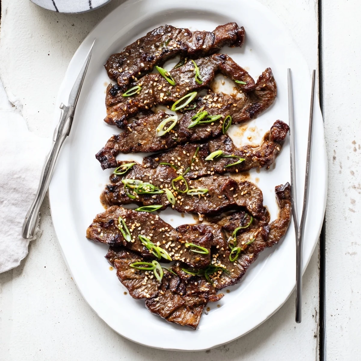 Flanken-cut Korean galbi ribs arranged on a serving platter with steamed rice and kimchi accompaniment