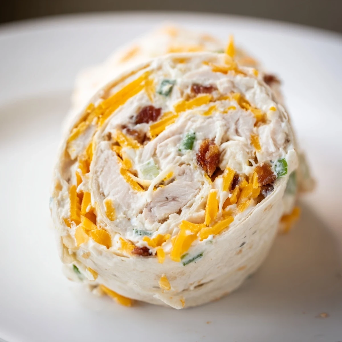 Spiral sliced tortilla wraps filled with creamy chicken, cheese, and crispy bacon pieces
