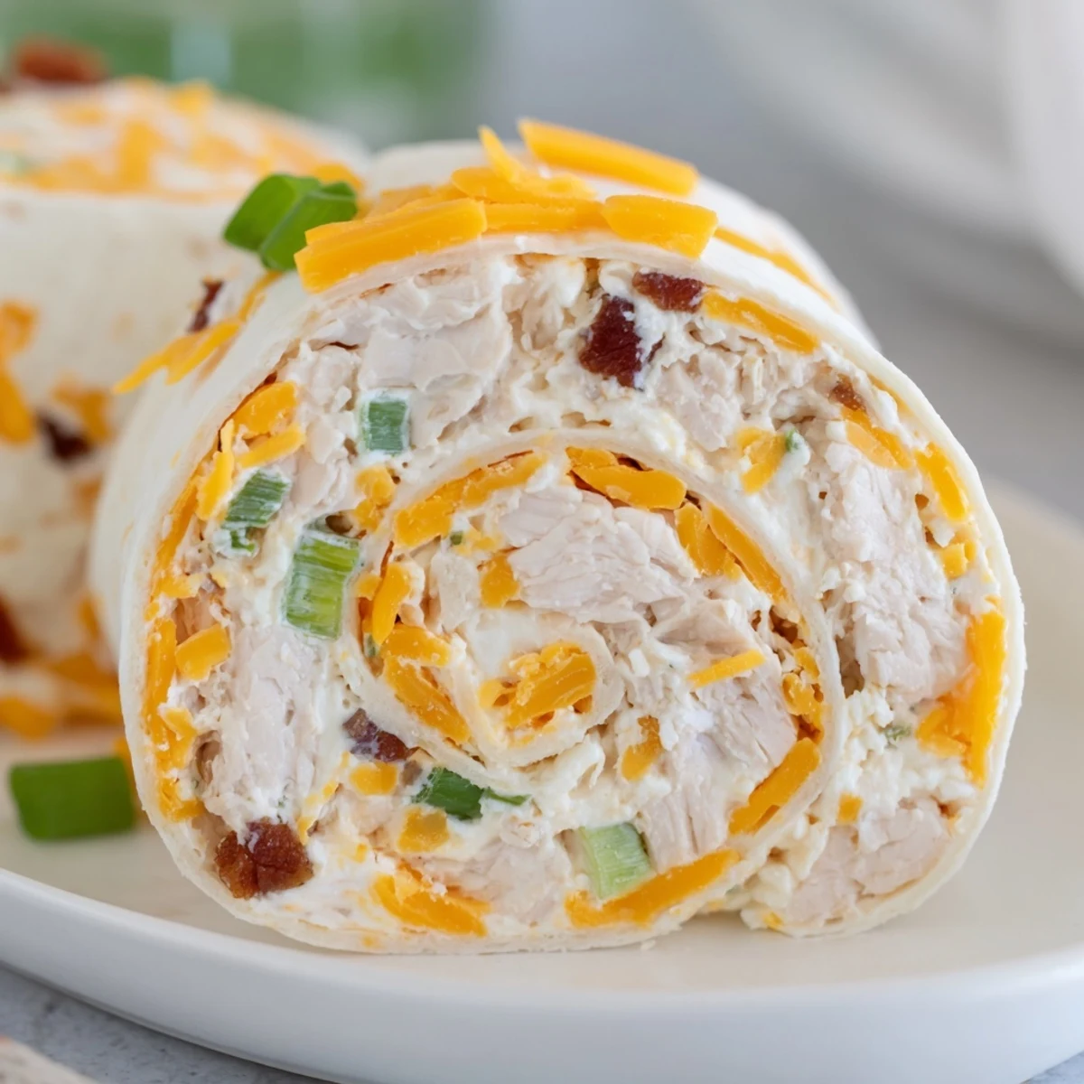 Party ready pinwheels showcasing layers of seasoned chicken salad rolled in soft flour tortillas