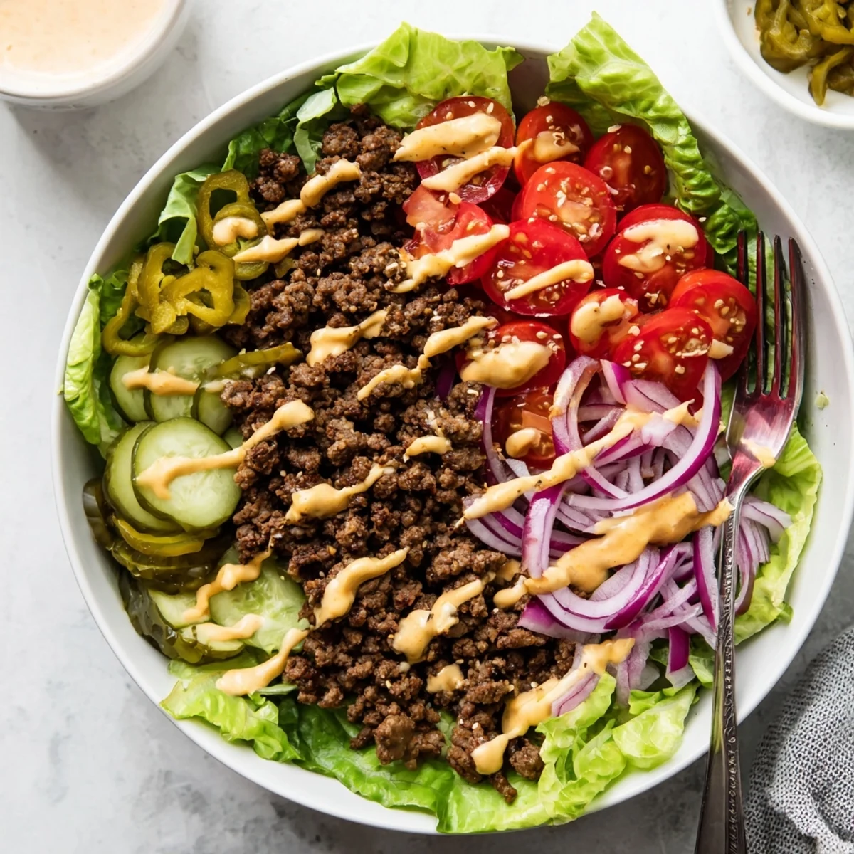 Low-carb burger bowls with juicy beef, melted cheddar, fresh vegetables, and creamy homemade dressing.