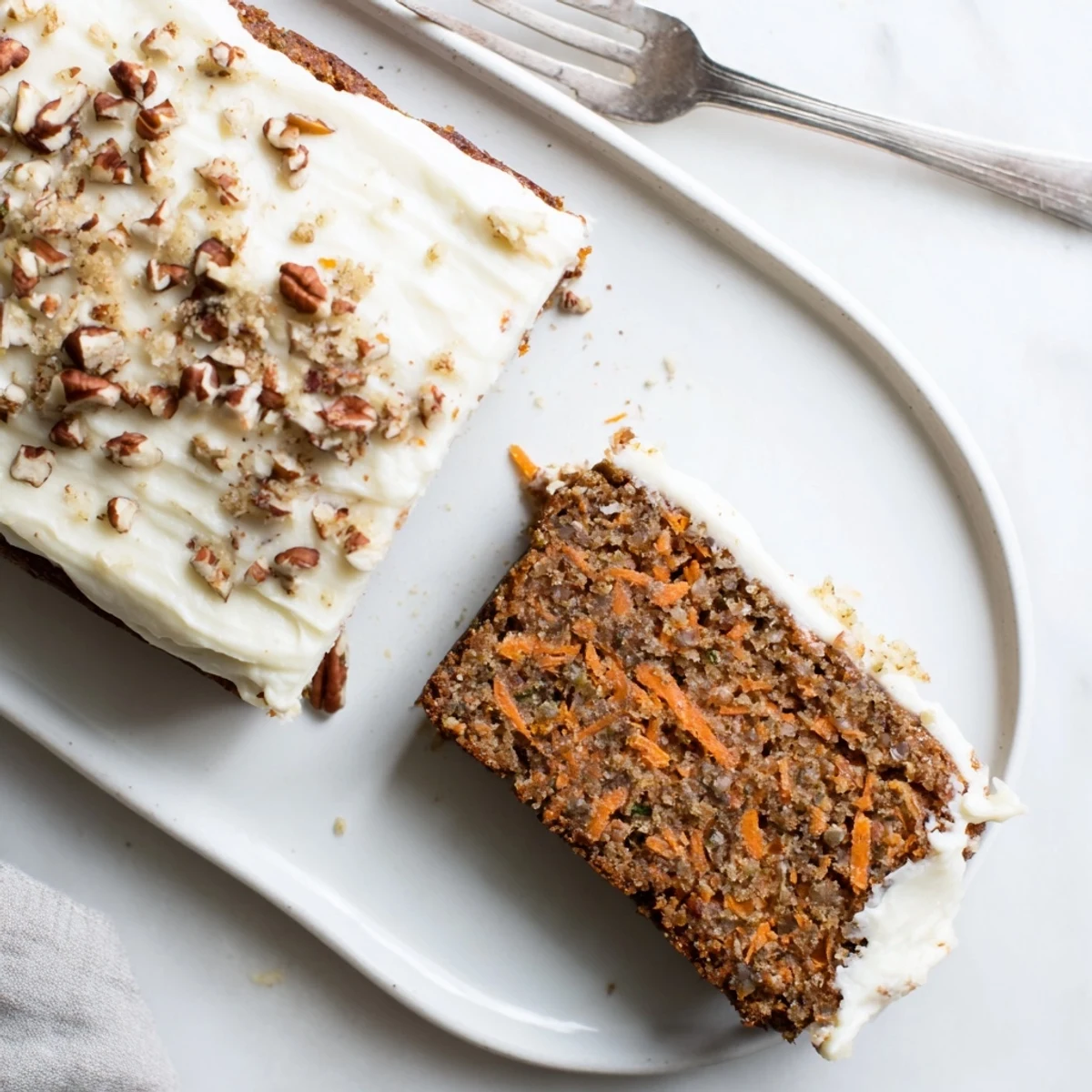 Square spiced carrot cake bars with fresh grated carrots and smooth cream cheese topping