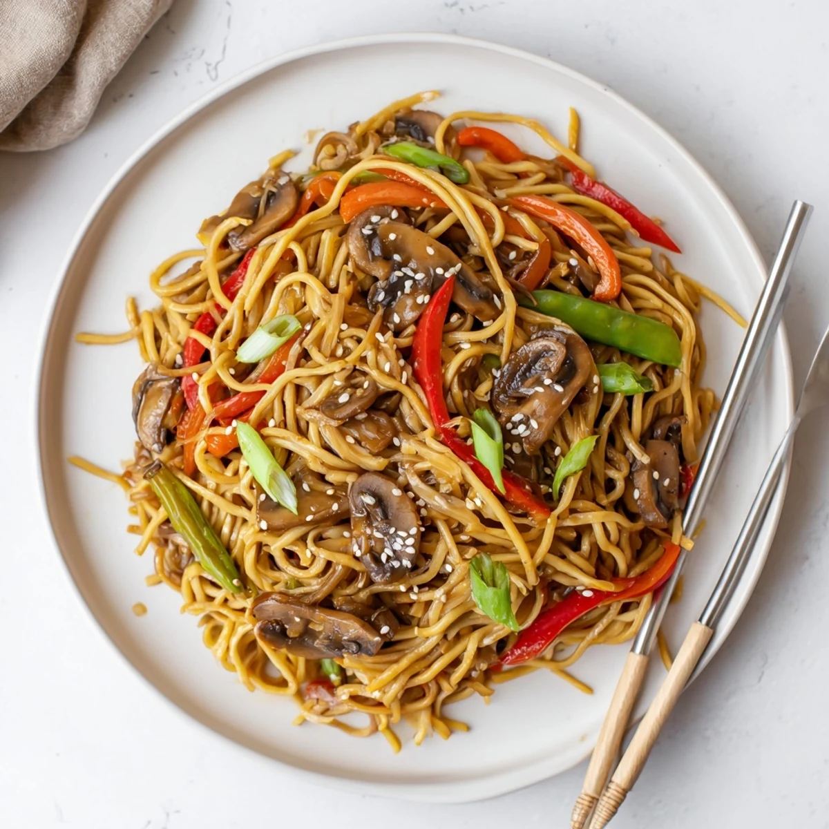 Colorful vegetable garlic mushroom chow mein noodles served family-style on rustic platter
