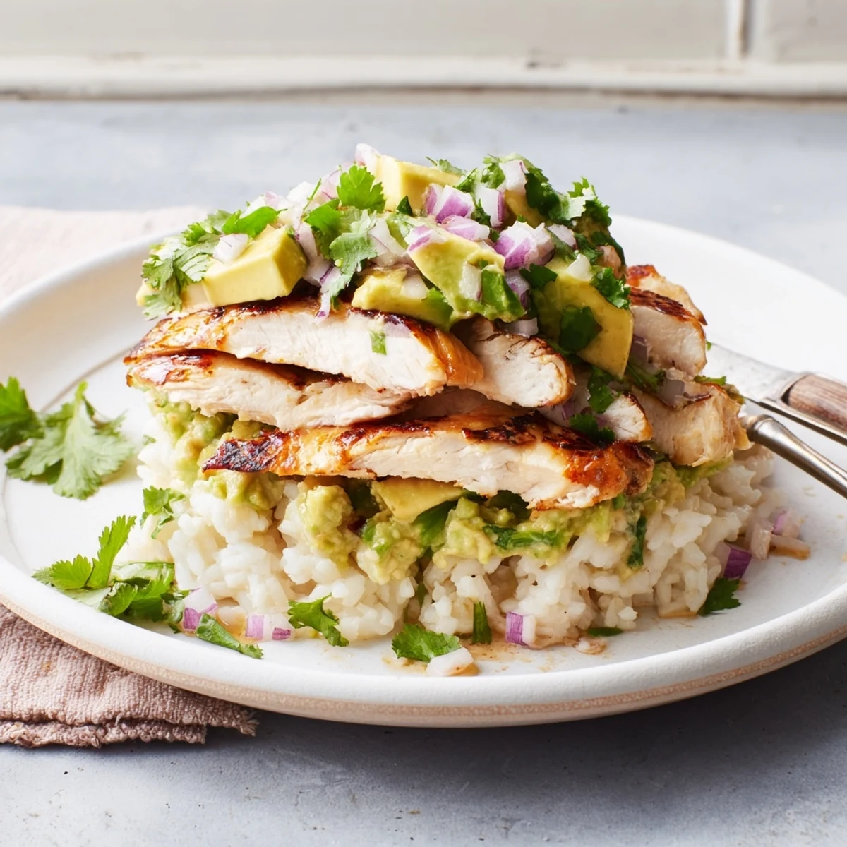 Golden honey lime chicken stacked with creamy avocado and fluffy white rice in a vibrant layered bowl