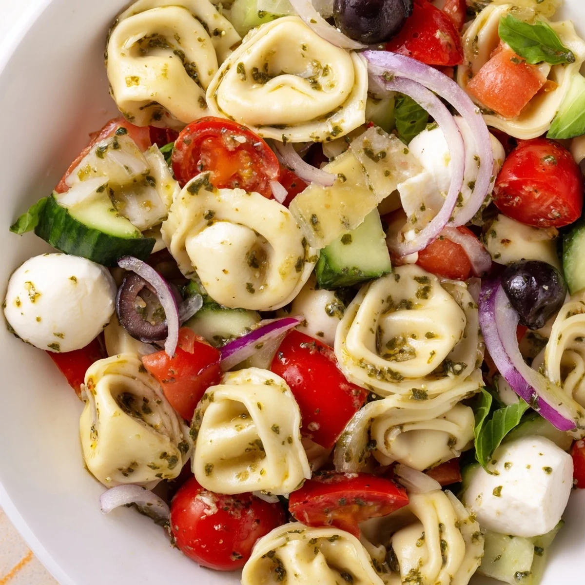 Tortellini pasta salad tossed with crisp vegetables and creamy mozzarella in Italian dressing