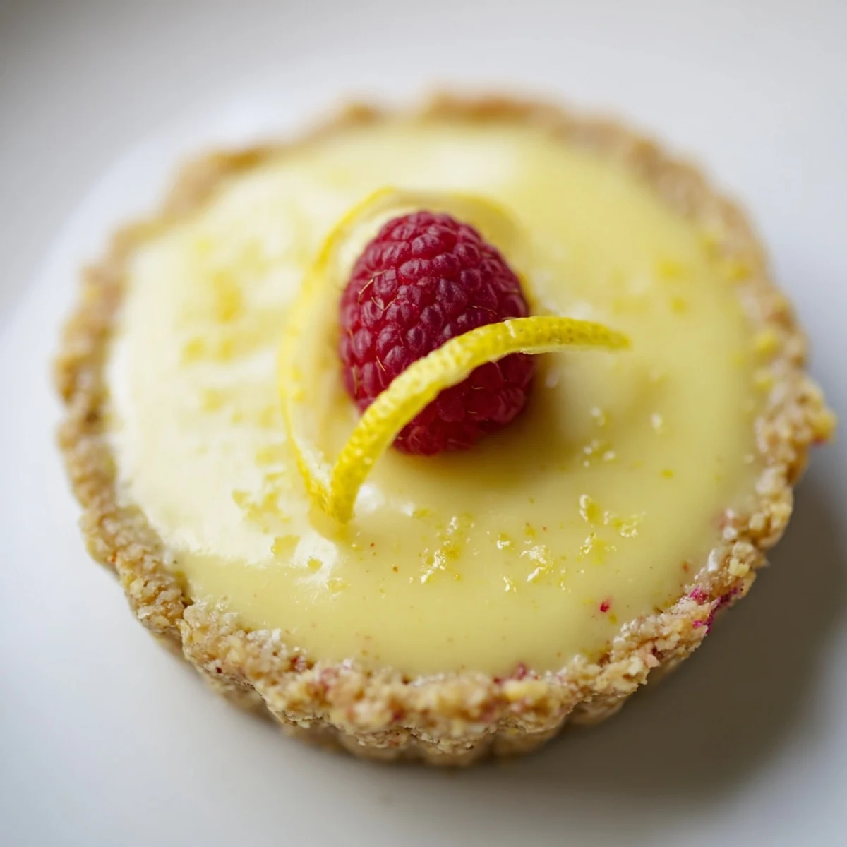 Mini vegan lemon tarts in crisp almond crusts dusted with powdered sugar
