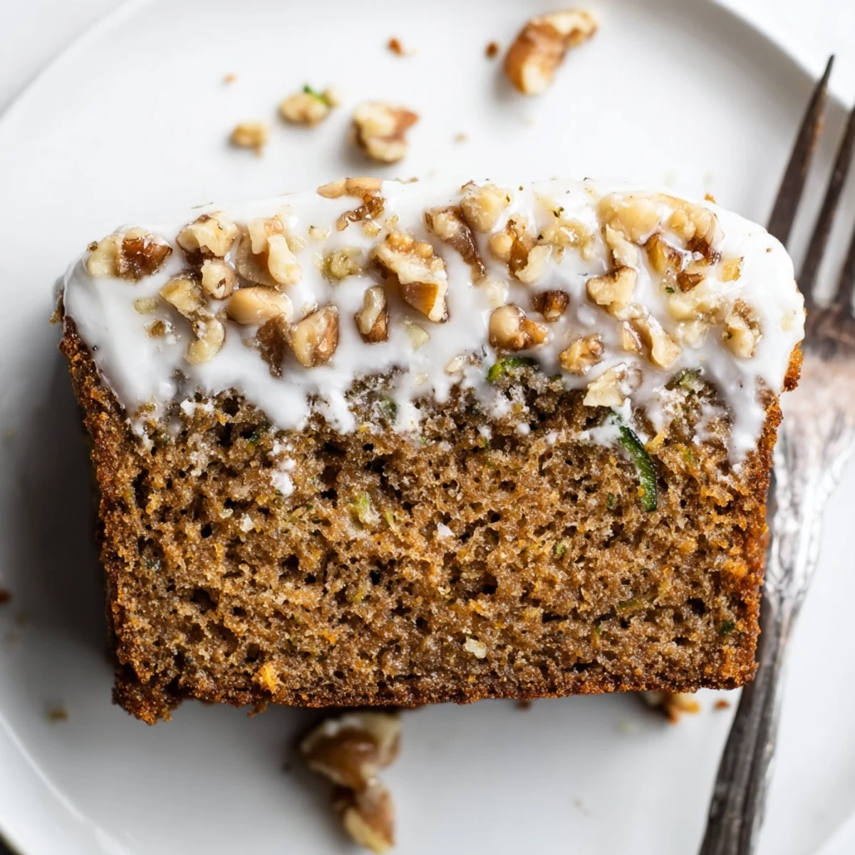 Slice of Zucchini Cake With Brown Sugar Icing served with steaming coffee.