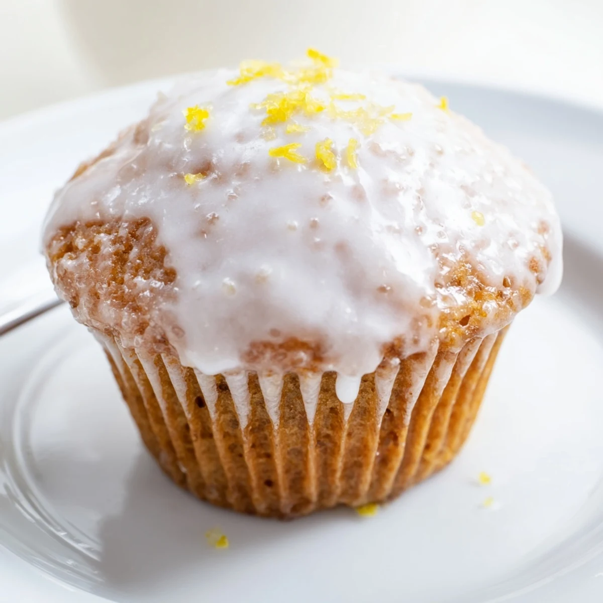 A stack of Glazed Lemon Ginger Muffins beside tea, zesty and tender
