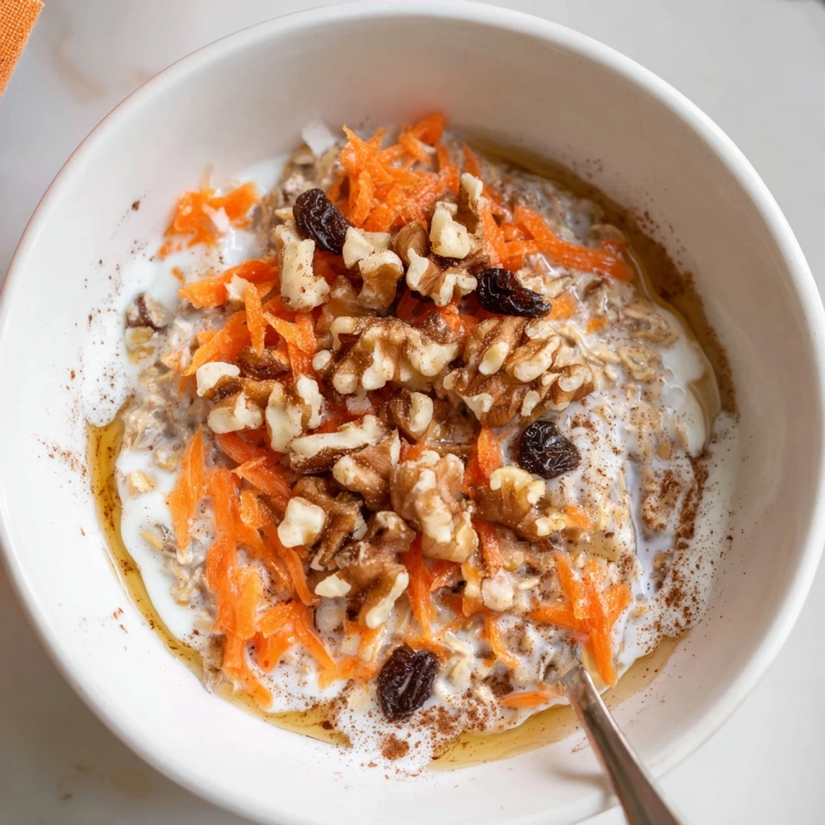 Creamy Carrot Cake Overnight Oats in a jar, scented with cinnamon, topped with walnuts.