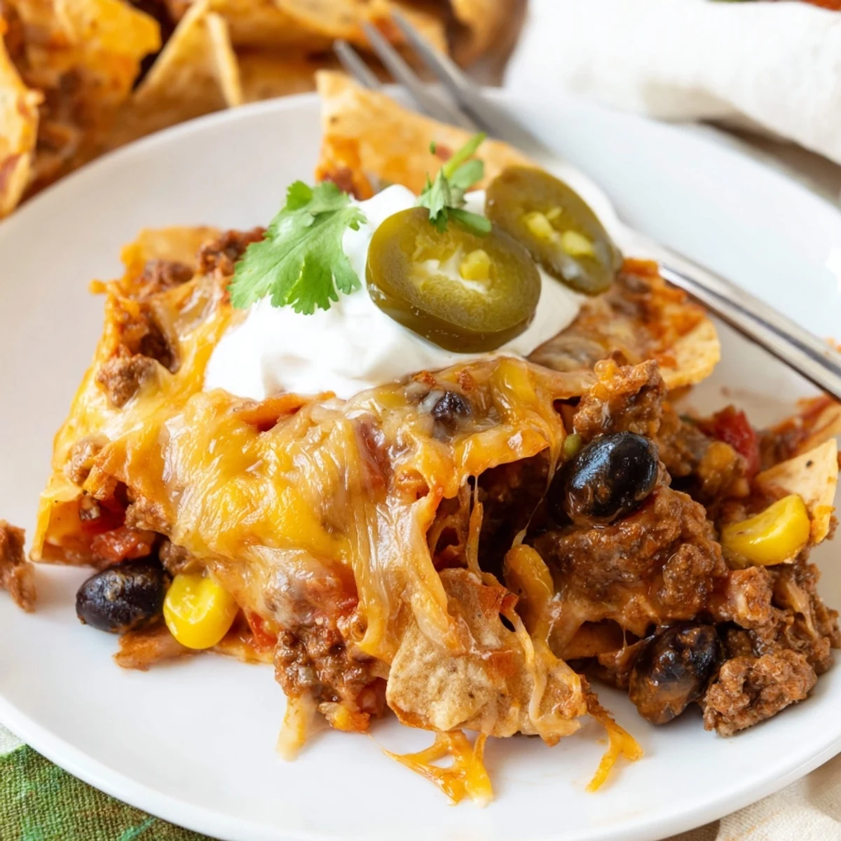 Cheesy Nacho Casserole bubbling golden, layered with crunchy chips and melted cheddar