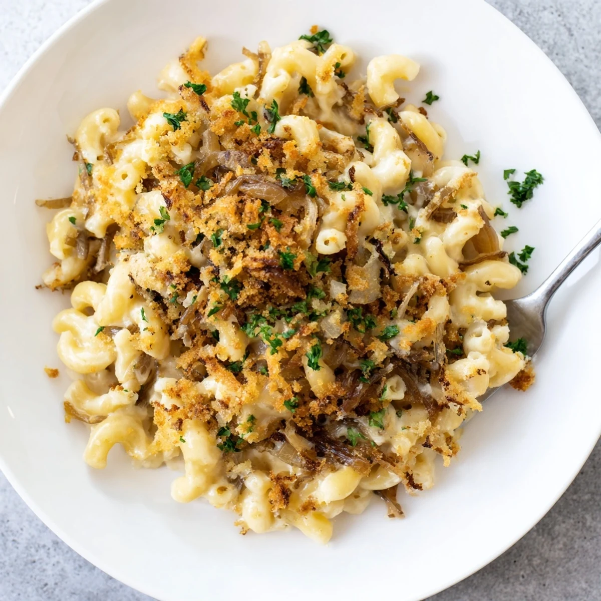 Creamy French onion mac and cheese featuring caramelized onions draped over rich cheese-covered pasta