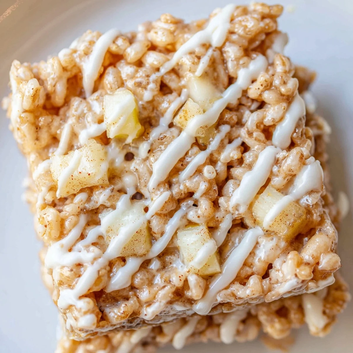 Golden pan of Apple Pie Rice Krispie Treats with gooey marshmallow and caramelized apple chunks