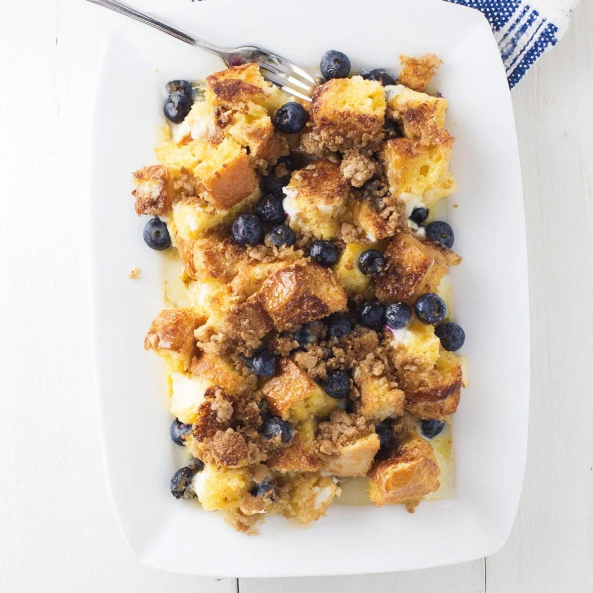 Golden blueberry cream cheese French toast casserole with crispy cinnamon streusel topping
