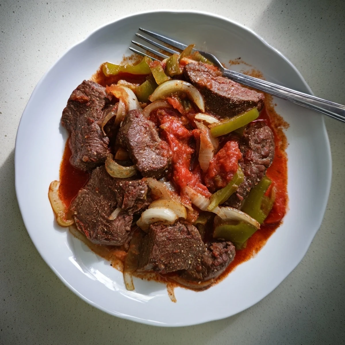 Old fashioned Swiss steak with beef served over creamy mashed potatoes