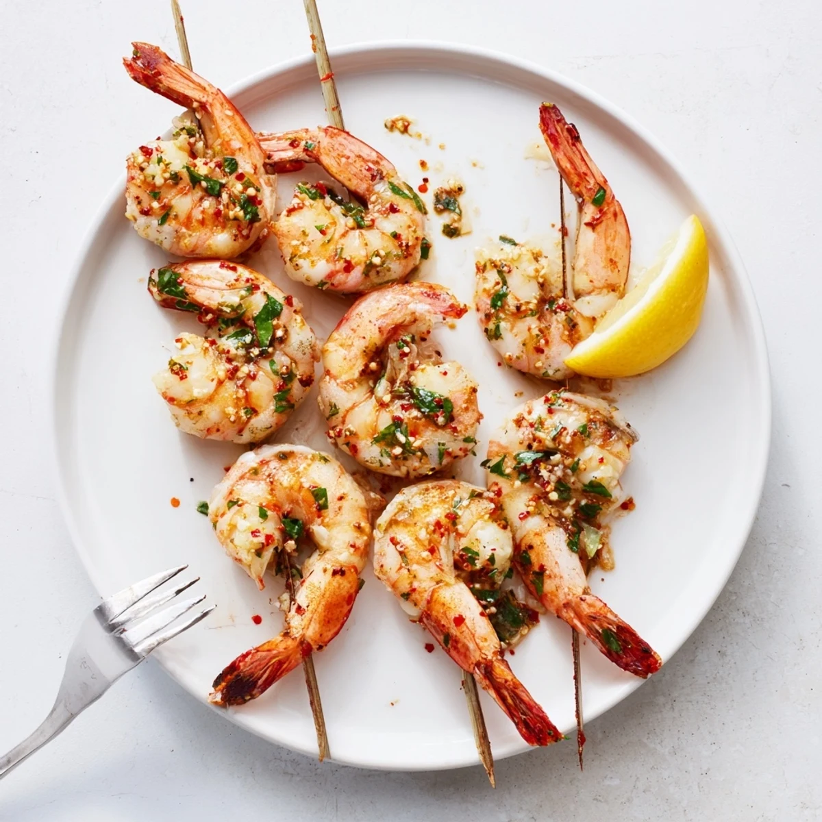 Marinated Grilled Shrimp glistening with lemon, smoky char, served on skewers.