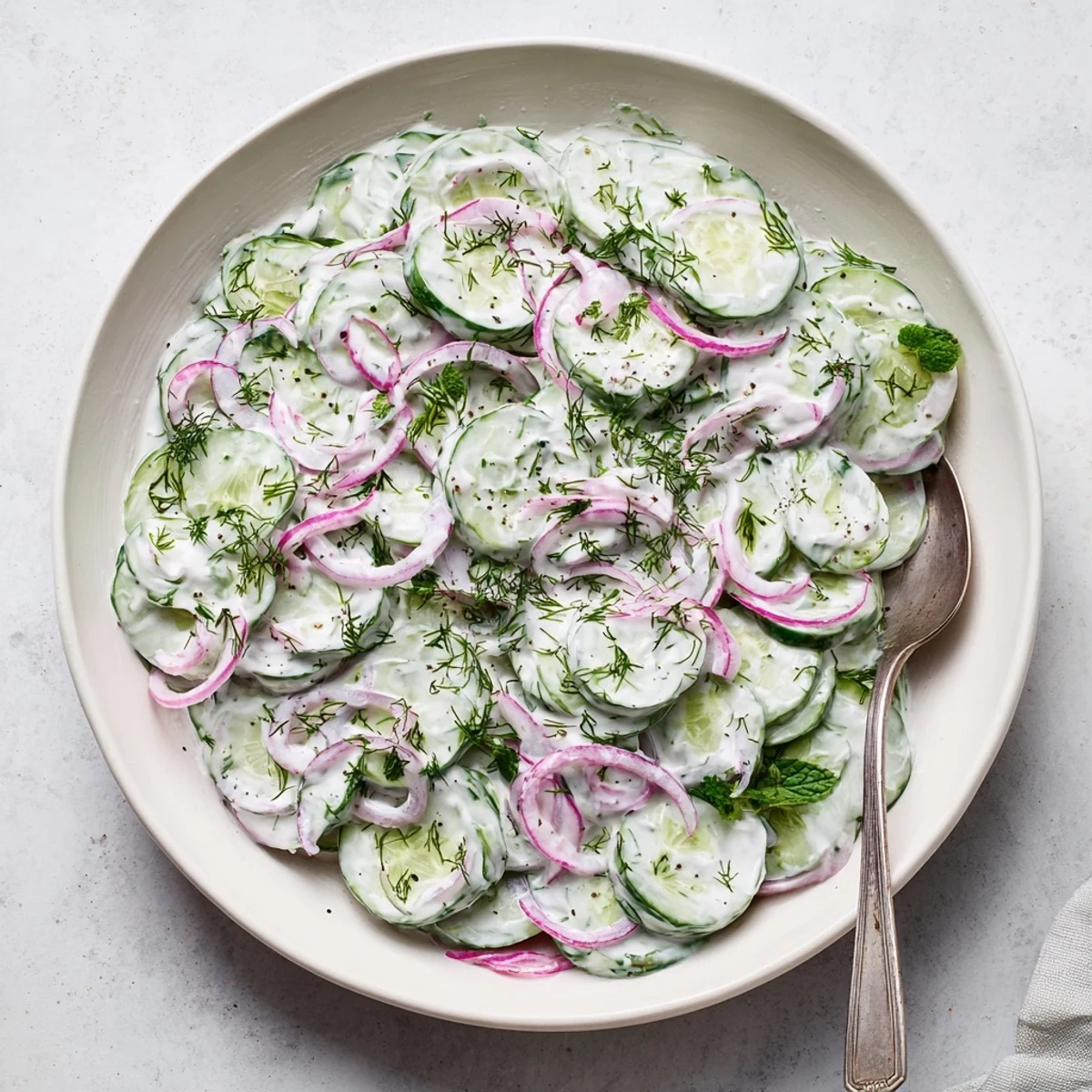 Creamy Greek yogurt cucumber salad featuring crisp cucumber slices, red onion, and fresh green dill