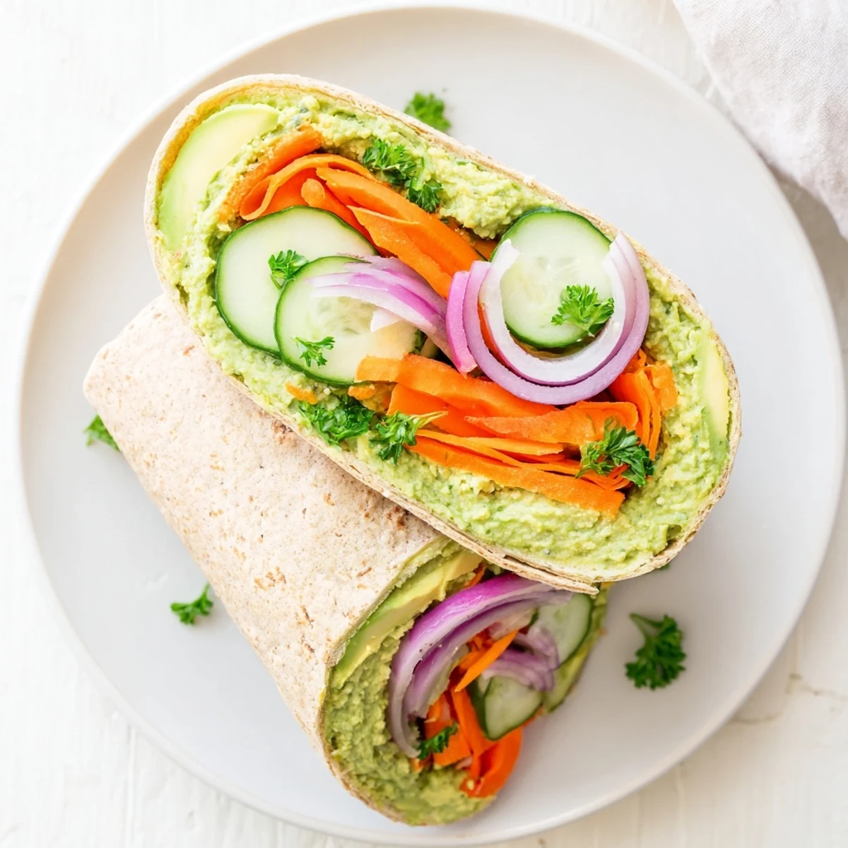 Whole wheat tortilla wrapped with vibrant green spinach hummus and colorful fresh vegetable layers