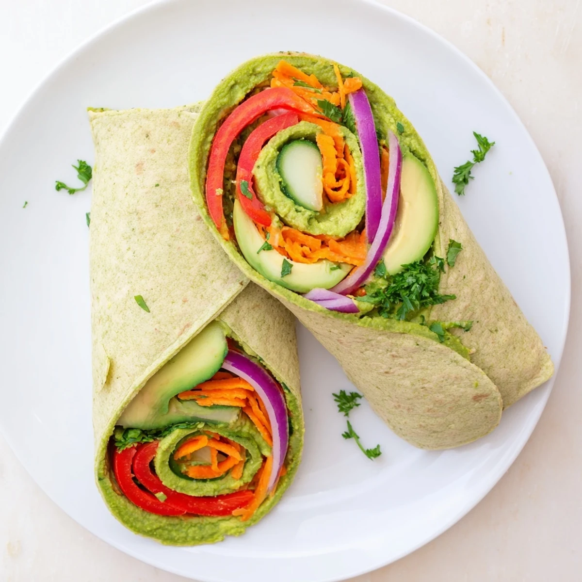 Mediterranean-style spinach hummus lunch wraps featuring crisp peppers carrots and sliced avocado
