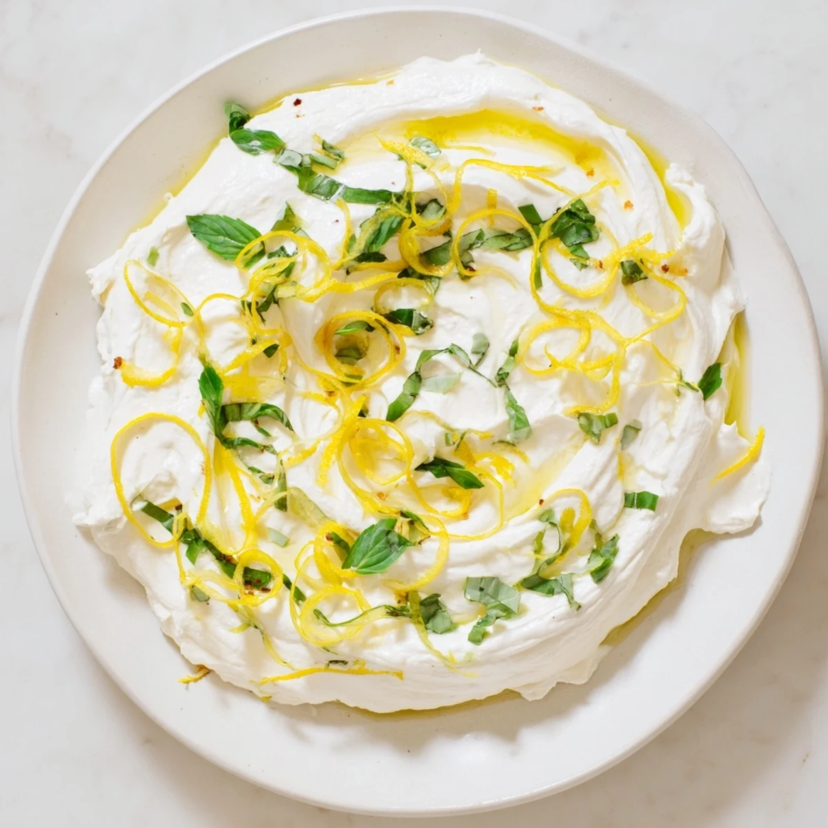 Fluffy white whipped ricotta spread served with toasted bread and honey drizzle on a plate