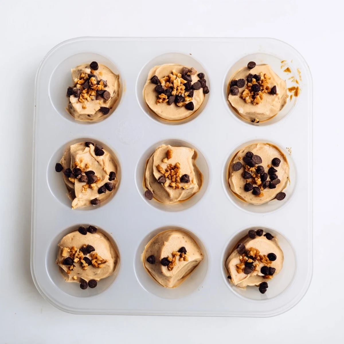 Frozen peanut butter Greek yogurt bites arranged on a white plate showing smooth creamy texture with chocolate chip garnish