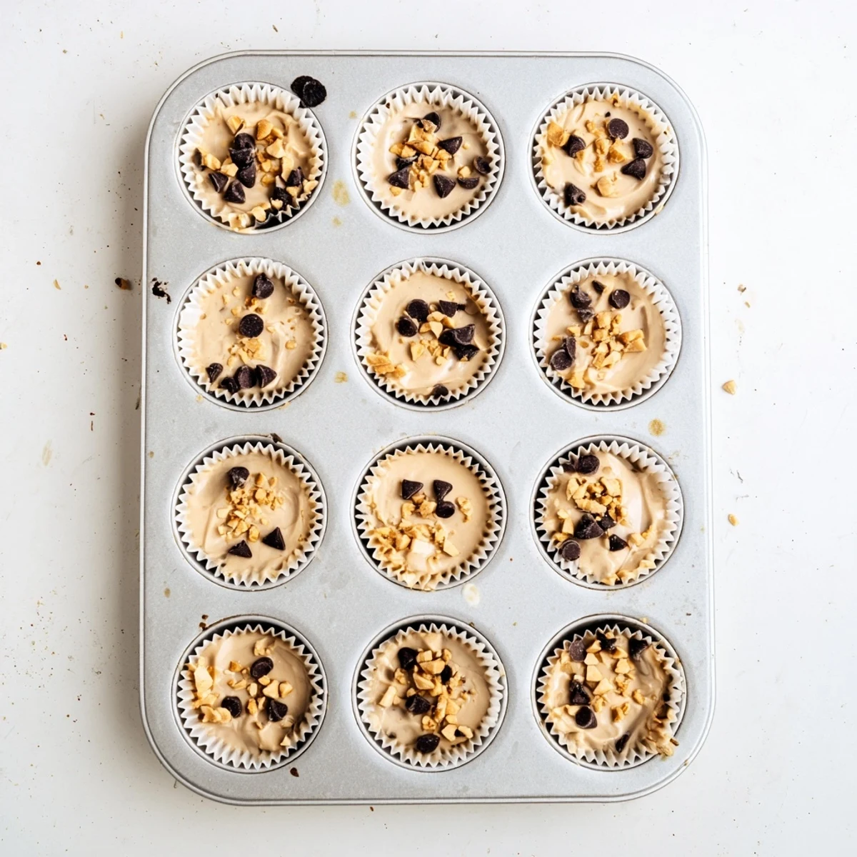 Close up of frozen peanut butter Greek yogurt bites with swirl patterns topped with crunchy peanuts and dark chocolate chips