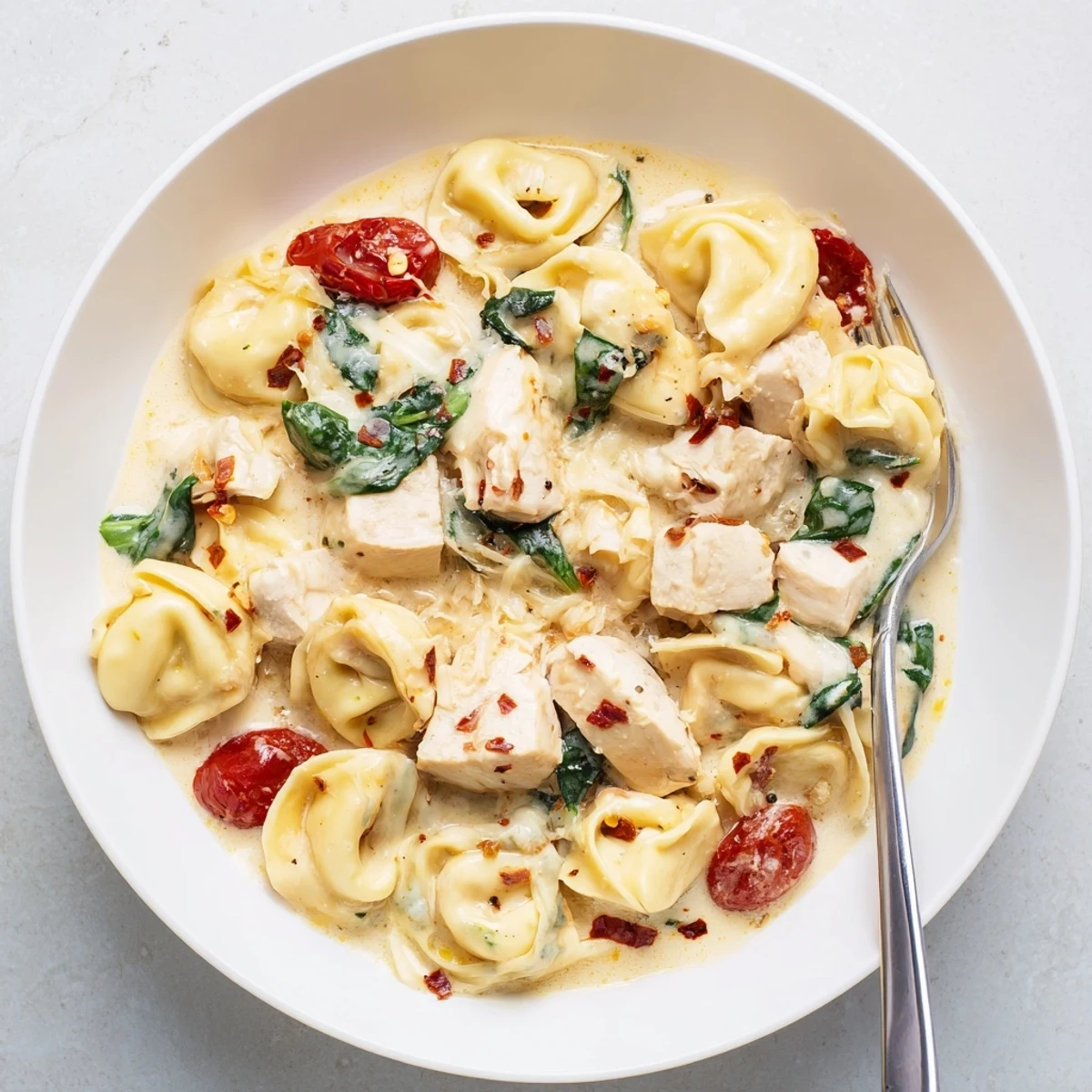 Slow Cooker Tortellini Casserole With Cheesy Chicken Pesto creamy, spoon-ready, topped with fresh basil