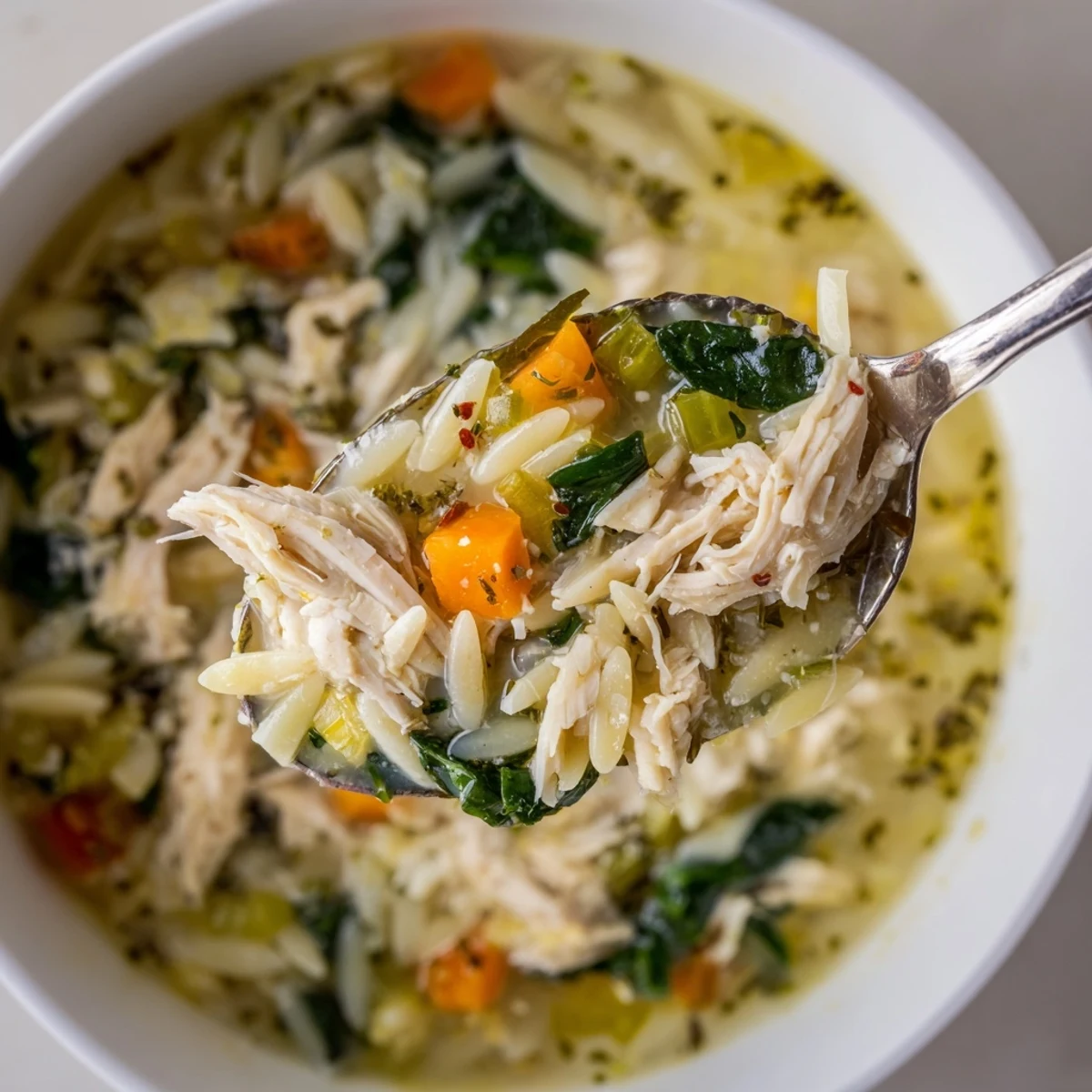 Creamy Chicken Florentine Soup With Orzo steaming in bowl, velvety broth and spinach