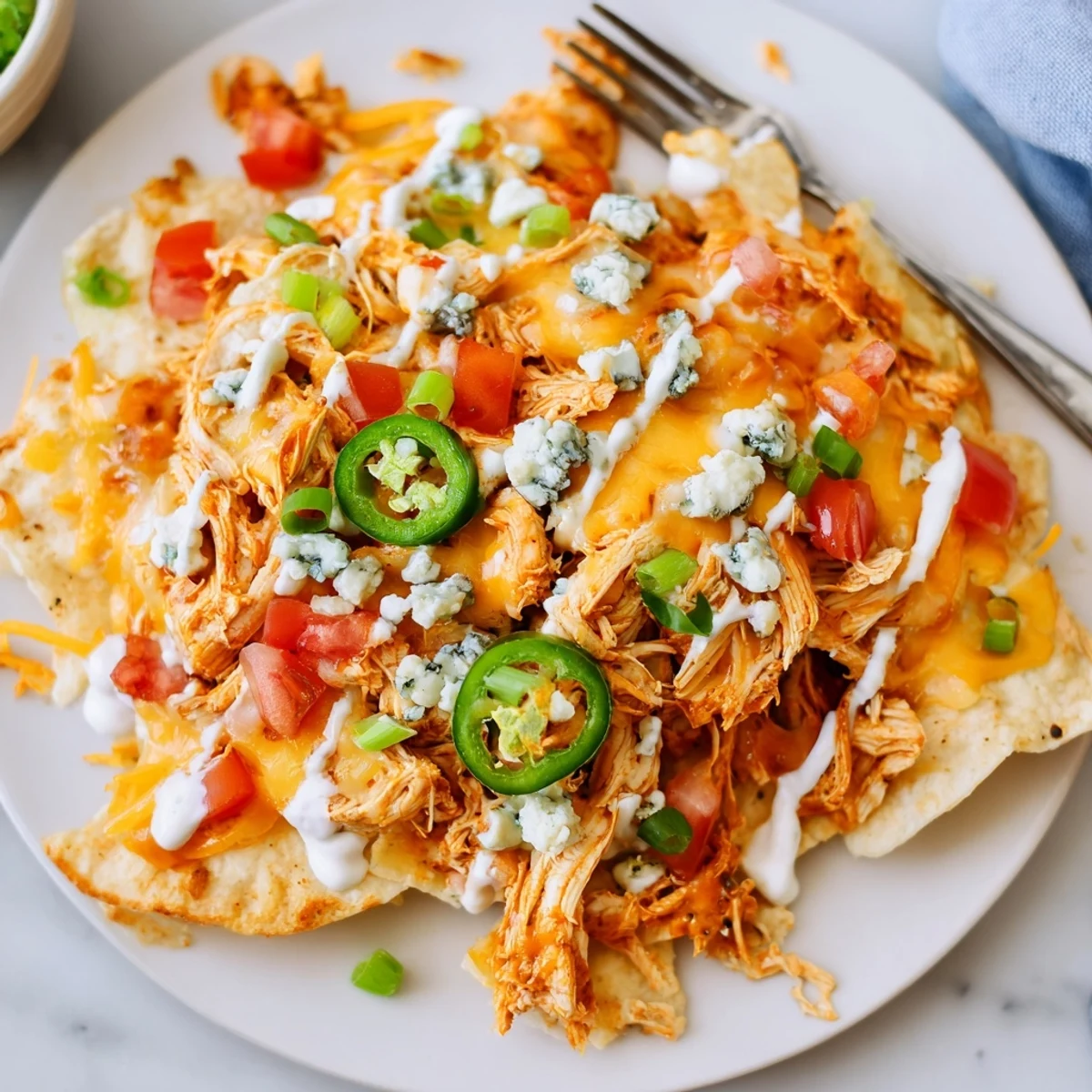 Buffalo Chicken Nachos piled with bubbling cheese, spicy shredded chicken, jalapeño slices