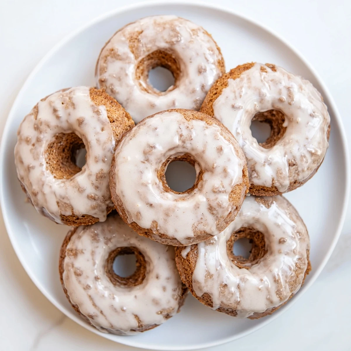 Moist baked banana bread donuts with warm cinnamon spice and powdered sugar coating