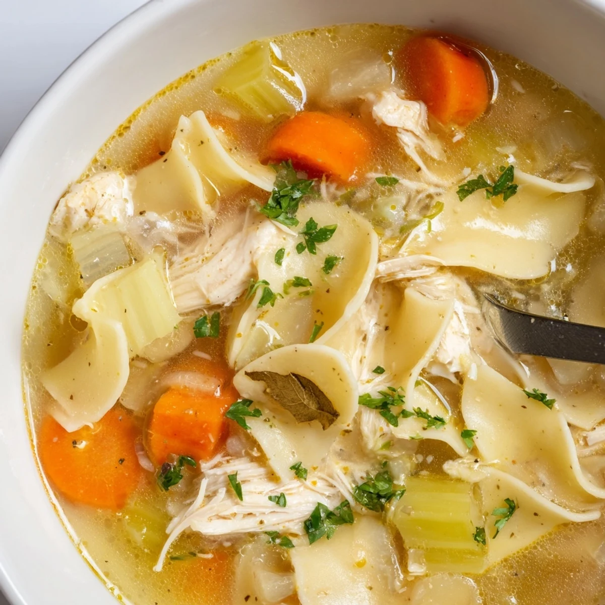 Bowl of Chicken Noodle Soup simmered to perfection, served with crusty bread