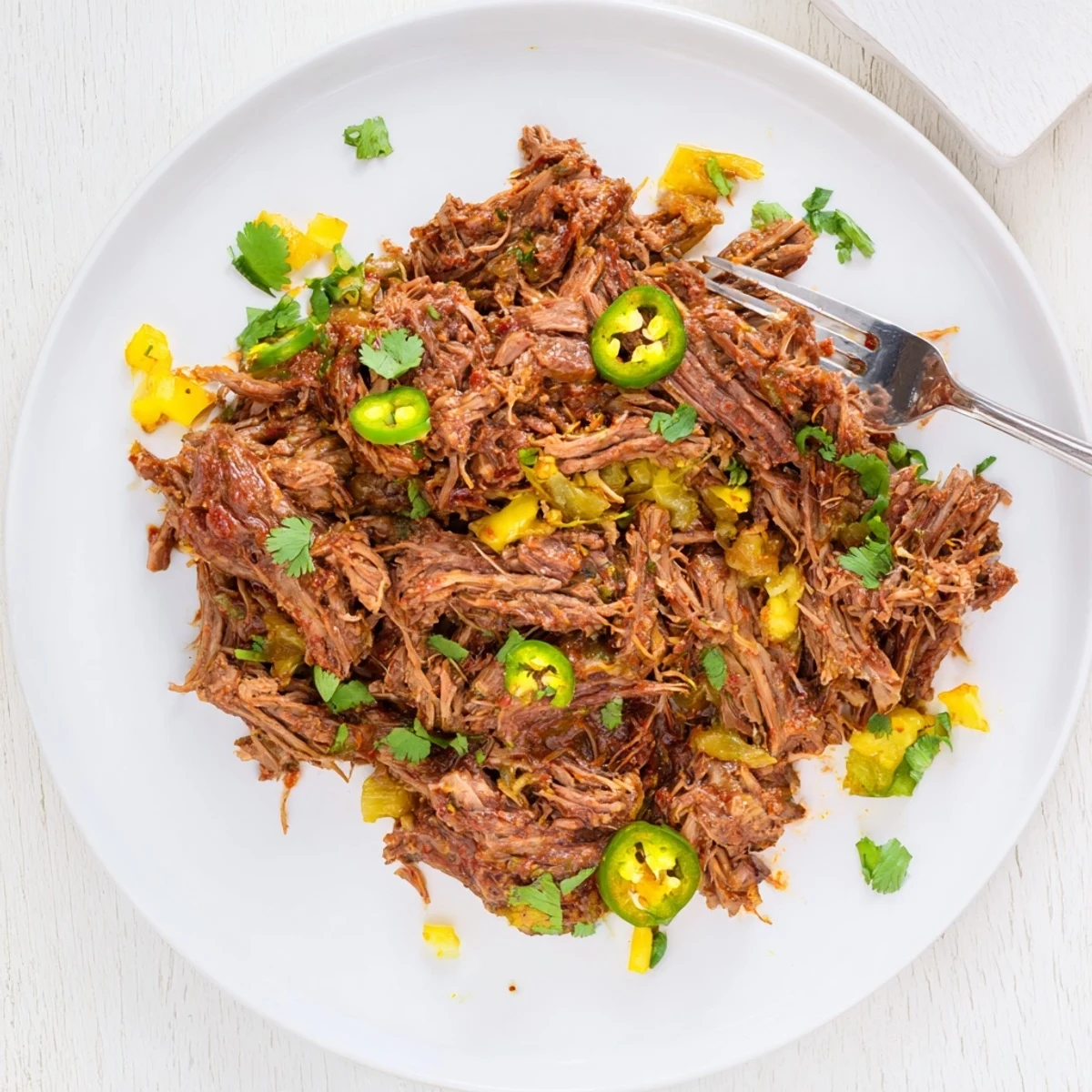 Savory Mexican slow cooker beef barbacoa piled high with fresh toppings for tacos or burritos