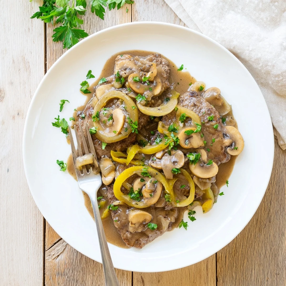 Fork-tender smothered cube steaks in thick savory gravy alongside buttery mashed potatoes for a hearty Southern dinner