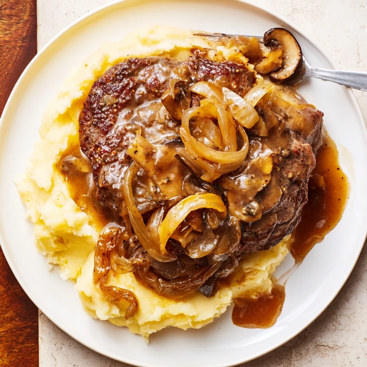 Country Style Smothered Cube Steak Recipe simmering in onion-mushroom gravy over mashed potatoes